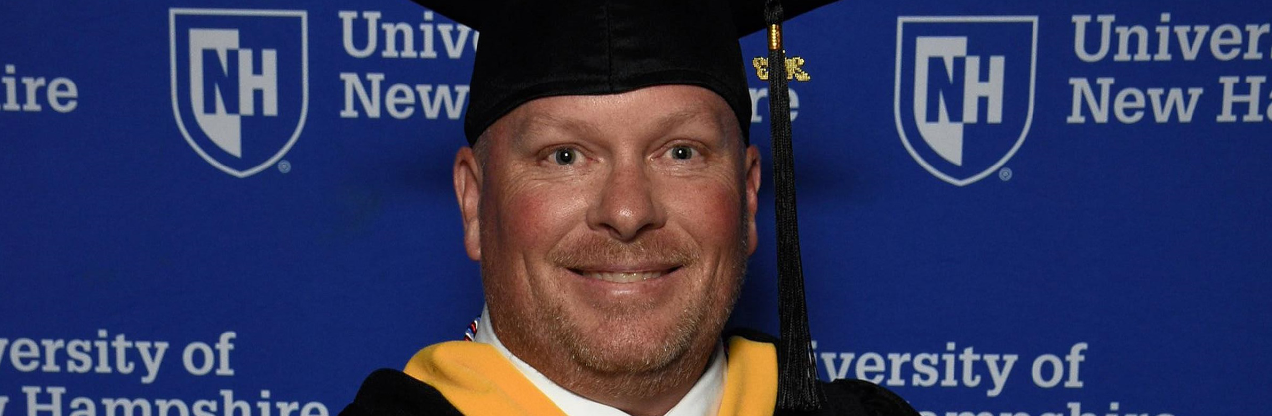 A close up of a man wearing a graduate cap
