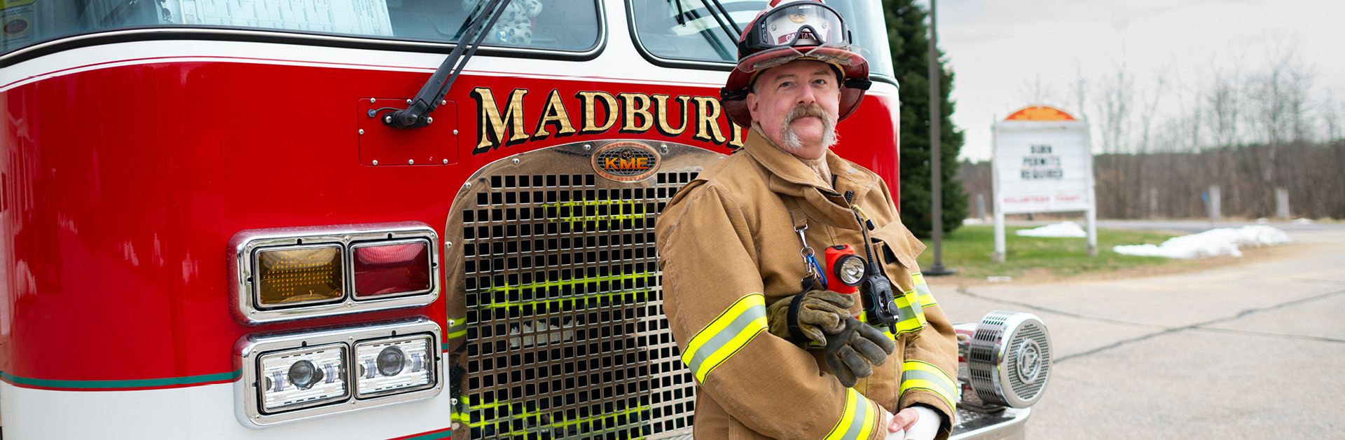 firefighter standing in front of a fire truck outside