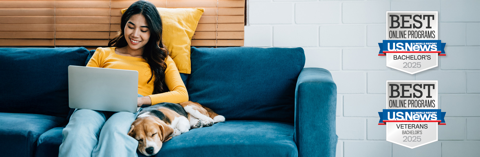 a woman sitting on a couch next to a sleeping dog, using a laptop