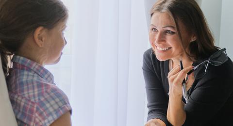 Smiling counselor talking with a young child