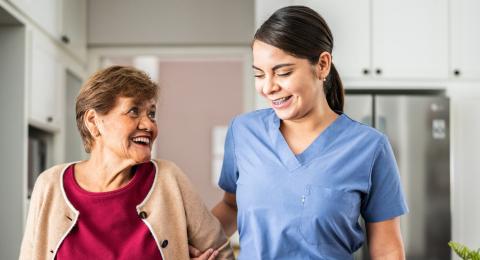 a younger woman helping an elderly woman in her home