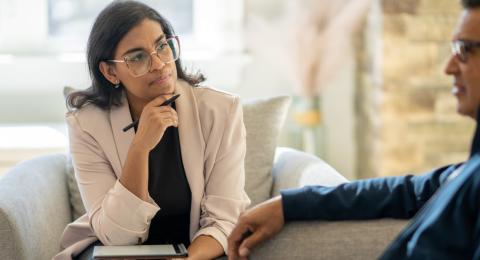 A female therapist listening to a male patient 