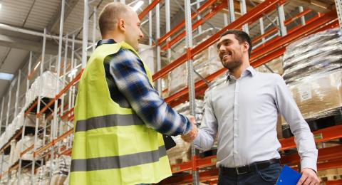 two men at working shaking hands in a warehouse