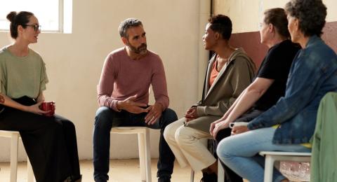 a small group of people talking during a group therapy session