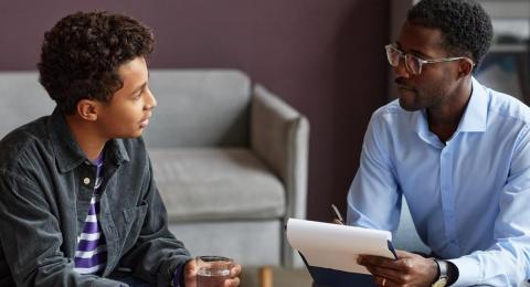 Teenage boy talking to a psychologist.
