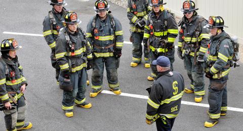 group of firefighters listening to instruction