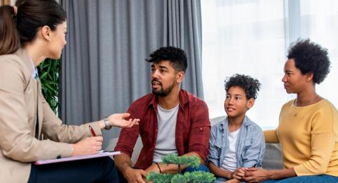 A family speaking with a female counselor.
