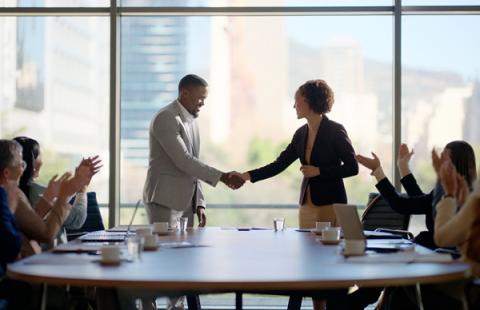 a man and woman in an office shaking hands