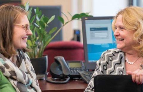 Two women talk at the office