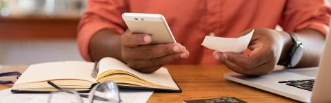 Man looking at calculator and receipt