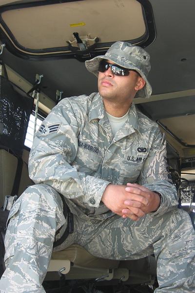 Photo of a man wearing military uniform and sunglasses, sitting down