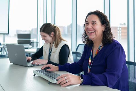 a woman sitting at a conference table smiling